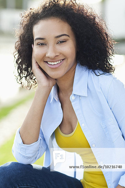 Close up of smiling Black woman sitting outdoors