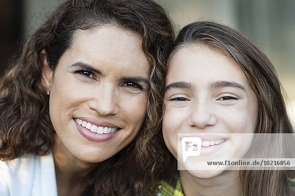 Close up of Hispanic mother and daughter smiling
