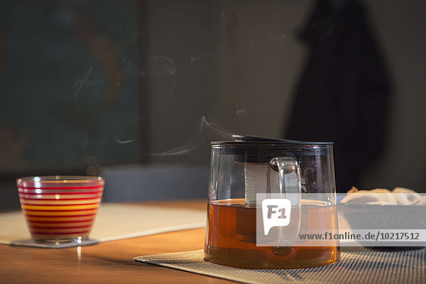 Steaming pot of tea on table