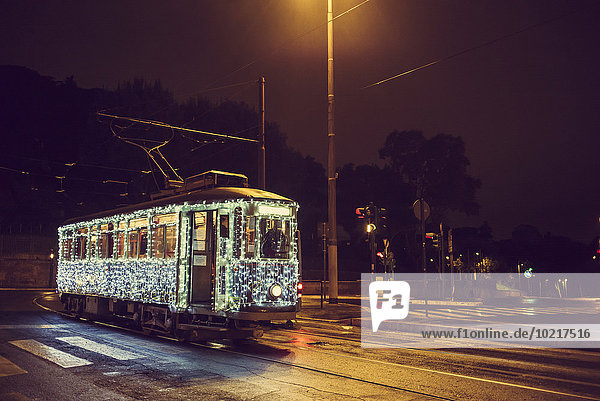 Illuminated streetcar on city street  Rome  Italy