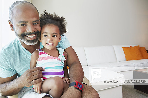 Black father and daughter sitting in living room