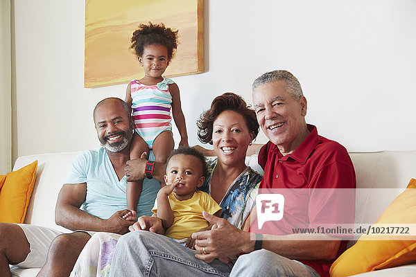 Multi-generation family smiling on sofa