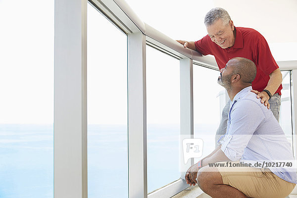Father and son standing on balcony