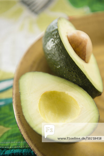 Close up of halved avocado in bowl