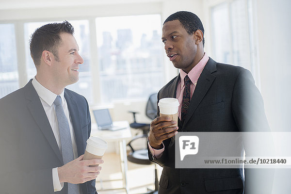 Businessmen drinking coffee in office