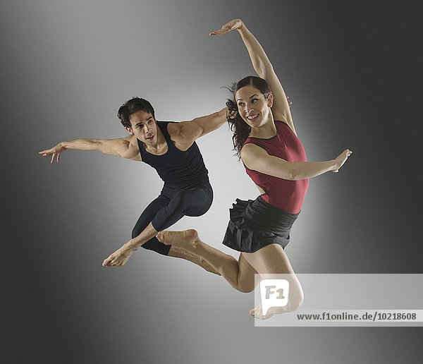 Hispanic dancers leaping in mid-air