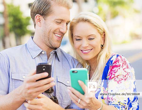 Caucasian couple using cell phones