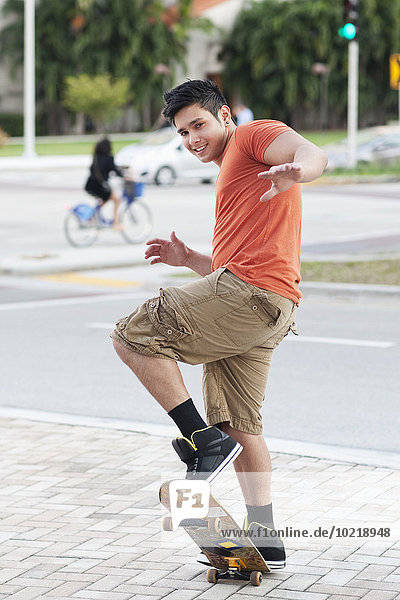 Mixed race man doing trick on skateboard