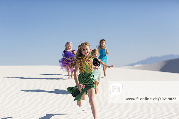 Girls running on desert sand dunes