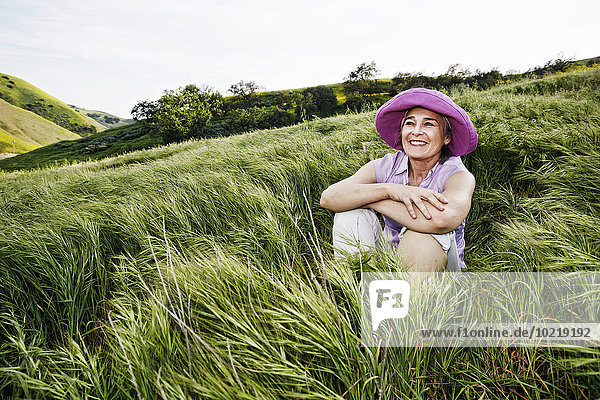 Caucasian woman sitting in tall grass