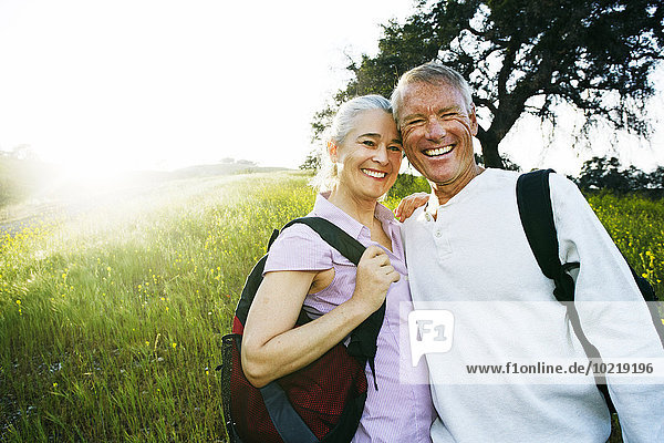 Caucasian couple smiling in tall grass