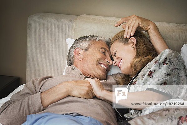 Laughing couple relaxing on bed