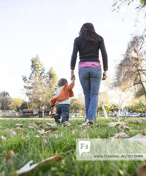 Hispanic mother walking with son in park