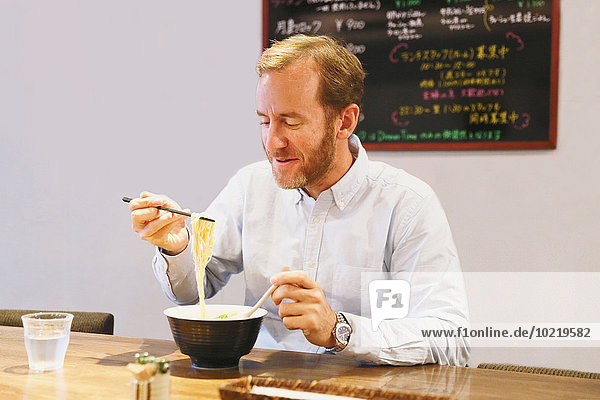 Europäer Mann essen essend isst Pasta Nudel Ramen