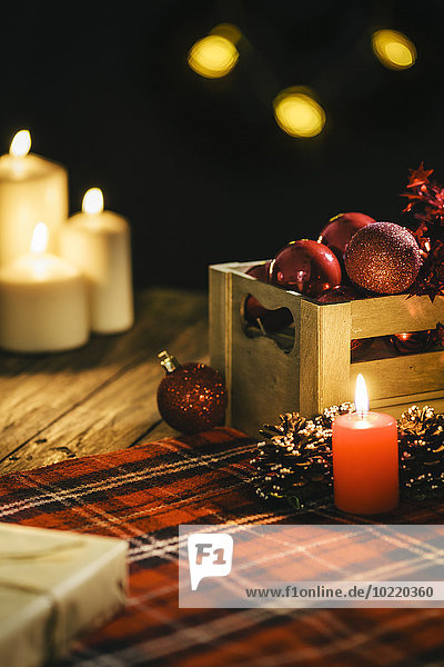 Christmas decoration with burning candles and checkered blanket