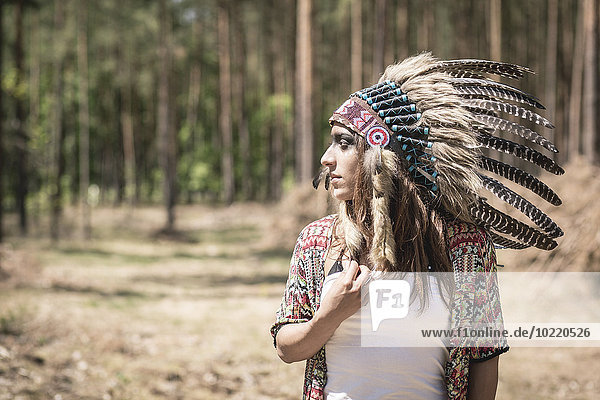 Junge Frau als Indianerin im Wald verkleidet