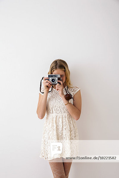 Junge Frau fotografiert mit alter Kamera