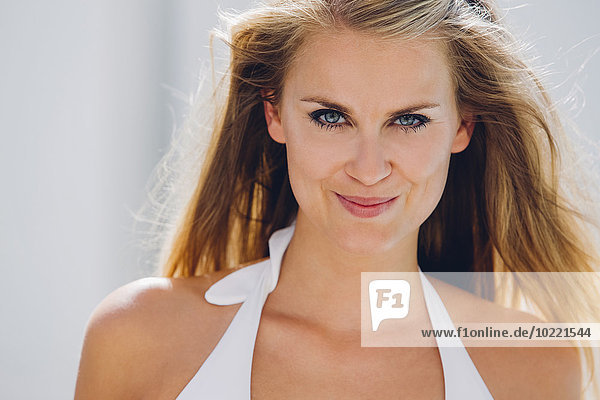 Porträt einer lächelnden blonden Frau im Bikini-Top