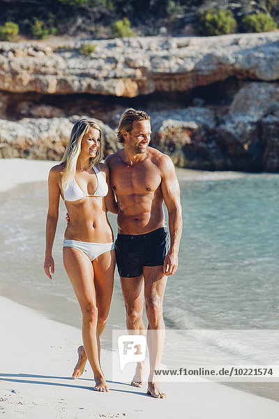 Spanien  Mallorca  lächelndes Paar beim Spaziergang am Strand
