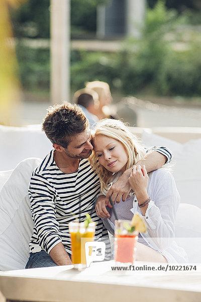 Young couple sitting together in an outdoor lounge
