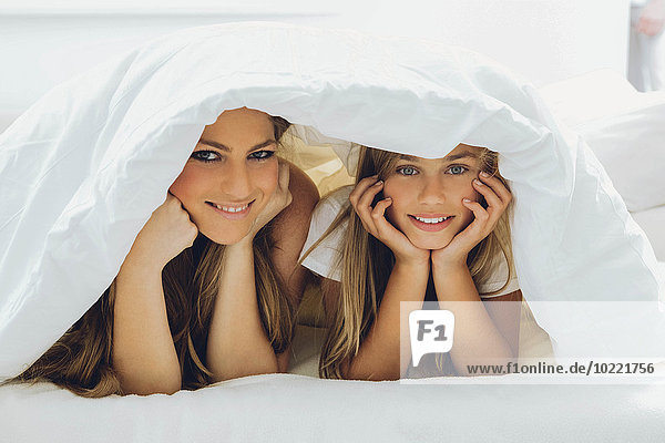 Glückliche Mutter und Tochter unter der Decke