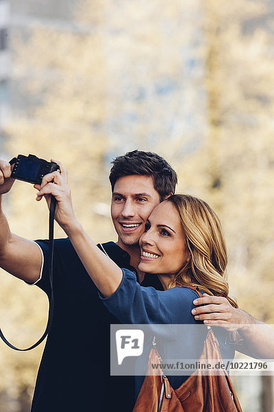 Smiling couple outdoors taking a selfie