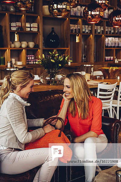 Two female friends relaxing in a coffee shop