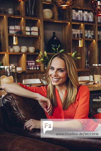 Porträt einer lächelnden blonden Frau in einem Café