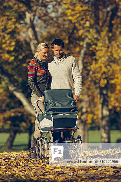 Couple with baby carriage in park