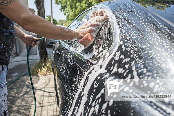 Mann beim Autowaschen  Nahaufnahme