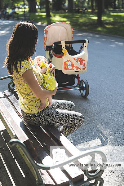 Mother with baby on park bench