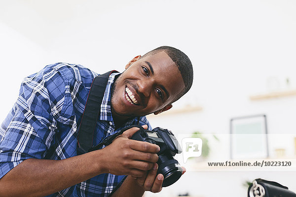 Porträt eines lächelnden jungen Mannes in seinem Fotostudio
