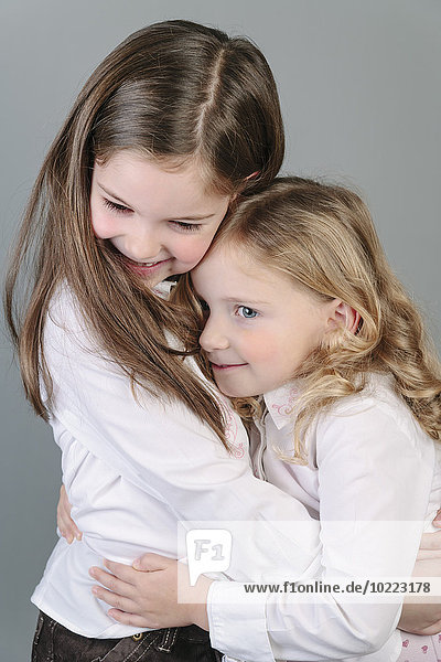 Two little sisters hugging