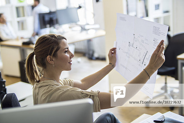 Woman in office looking at plan