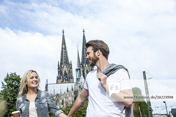 Germany  Cologne  happy young walking hand in hand