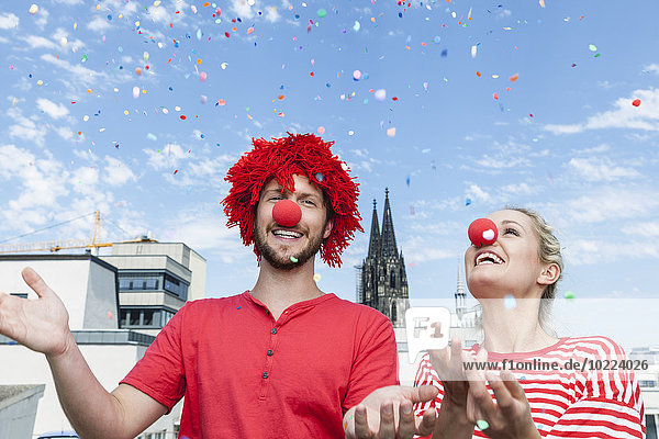 Germany  Cologne  young couple celebrating carnival dressed up as clowns