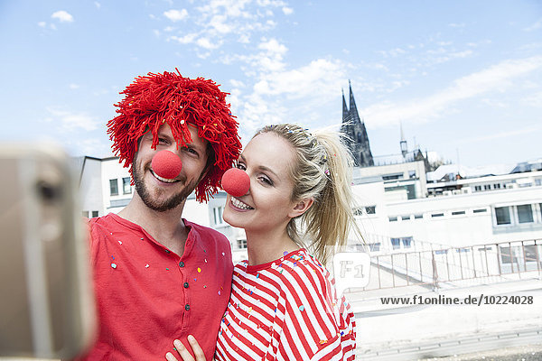 Deutschland,  Köln,  junges Paar feiert Karneval als Clowns verkleidet