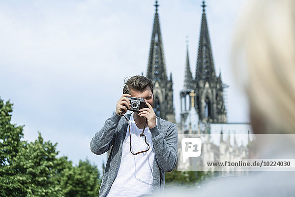 Germany  Cologne  man taking a picture of his girlfriend