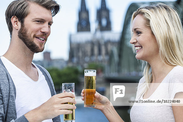 Germany  Cologne  happy young couple with Koelsch glasses