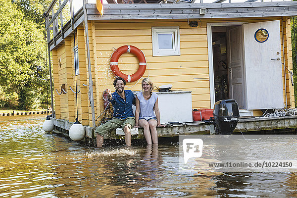 Glückliches Paar bei einer Fahrt auf einem Hausboot