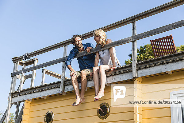 Paar auf der Dachterrasse eines Hausbootes sitzend