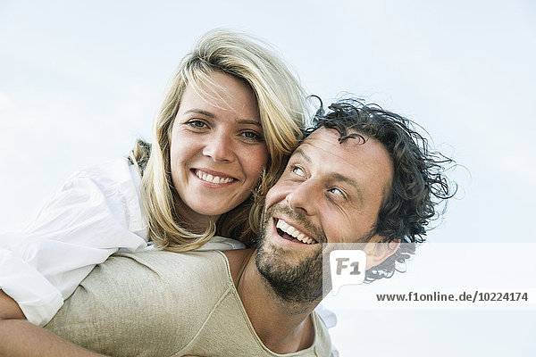 Lächelnder Mann mit Huckepack-Frau