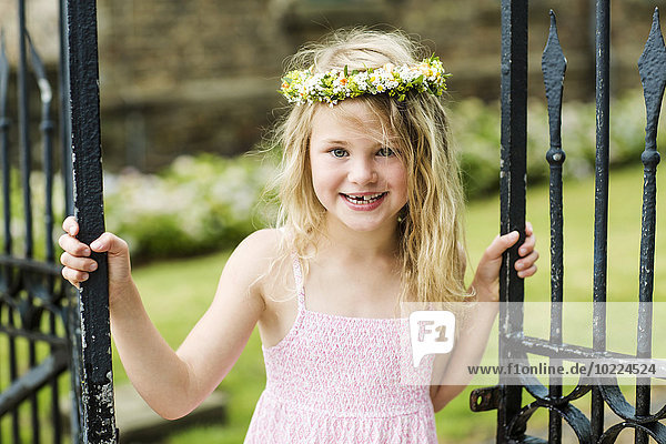 Portrait of smiling girl with tooth gap wearing floral wreath