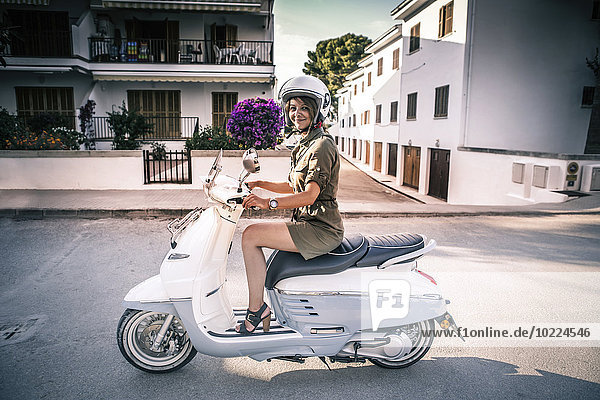 Spain  Majorca  Alcudia  woman on motor scooter