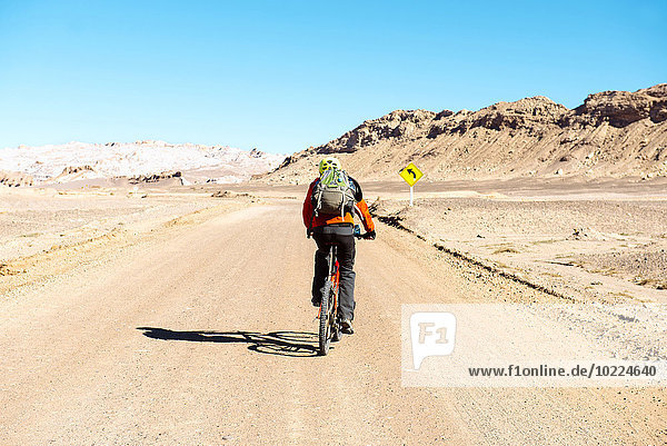 Chile  Man ridding a mountain bike throught the Valle de la Luna  Atacama Desert