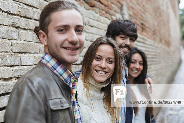Italien  San Gimignano  Gruppenbild von vier lächelnden Freunden