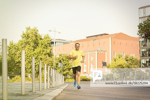 Germany  Stuttgart  smiling man jogging in the city