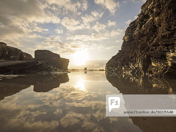 Spanien  Galizien  Ribadeo  Playa de Aguas Santas bei Sonnenuntergang  kleine Menschen am Strand