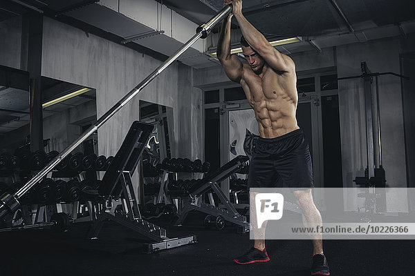 Physical athlete exercising with barbell