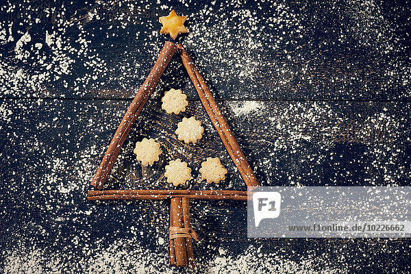 Zimtstangen und Kekse in Form eines Weihnachtsbaums